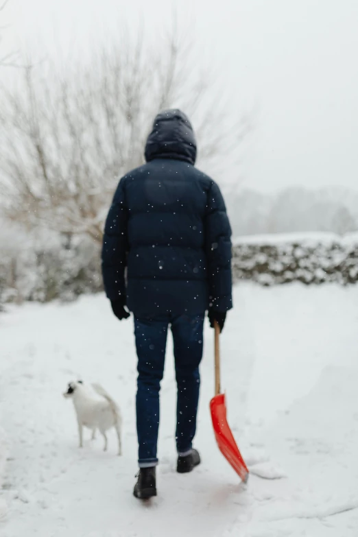 a person holding an umbrella is walking in the snow