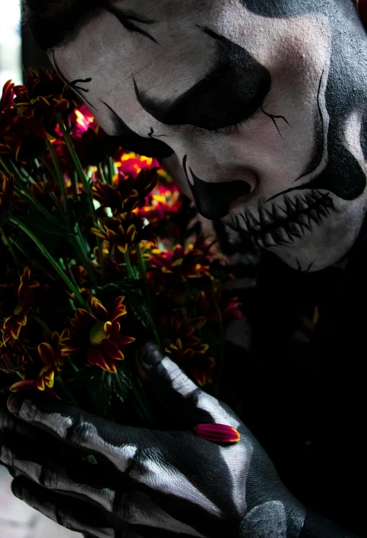 a skull painted doll holding flowers in a bouquet