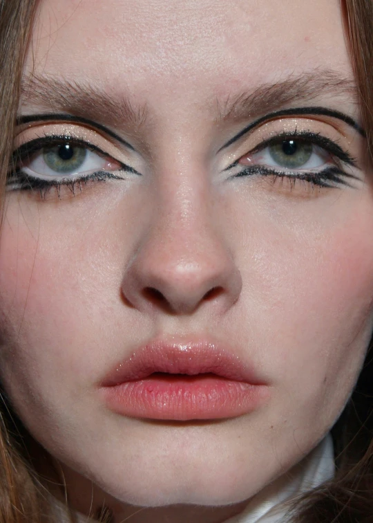 this model is wearing long lashes with a white collar