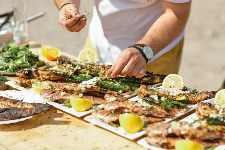 person placing food onto paper plates on the table