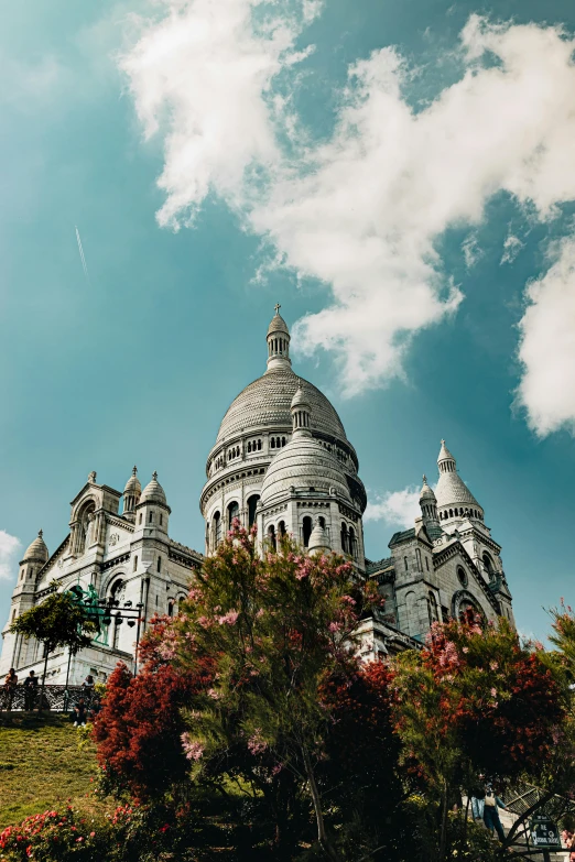 a very ornate old building is surrounded by beautiful flowers