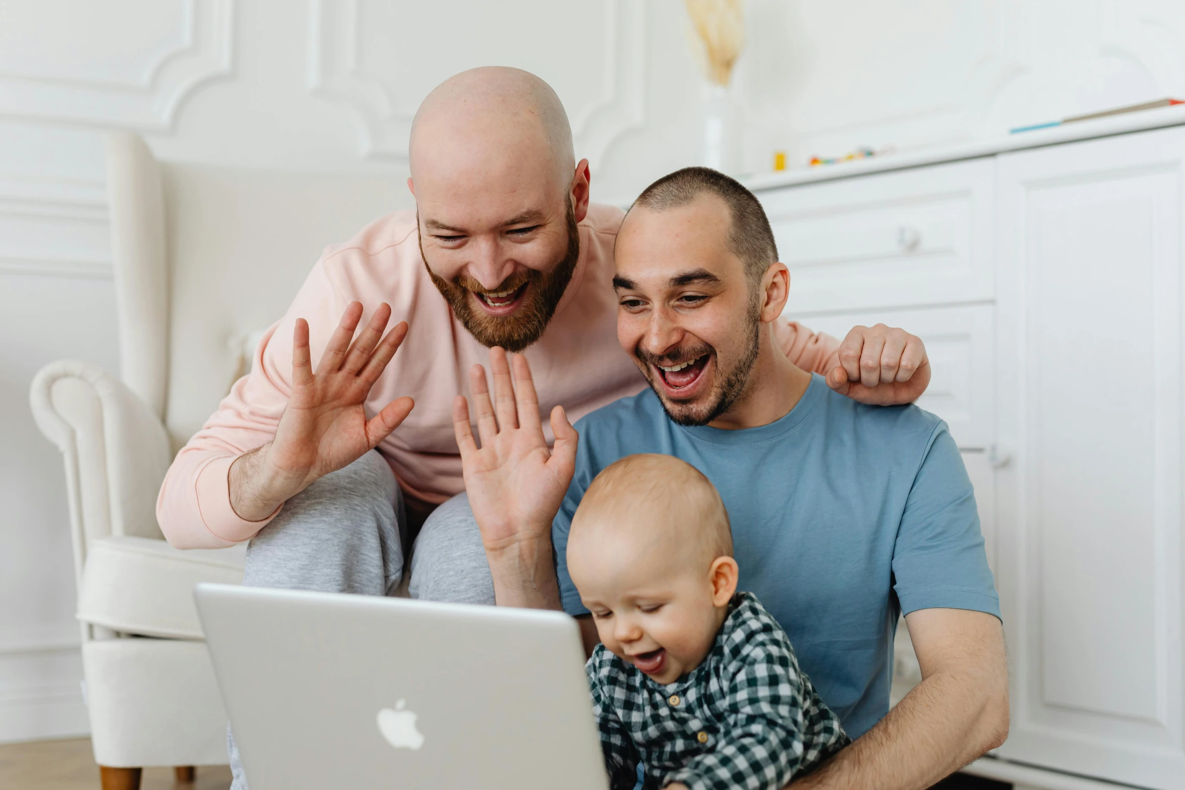 an image of two men laughing with a baby