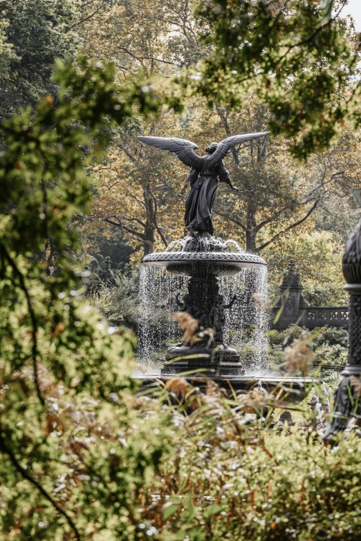 statue of an angel sitting on top of a fountain