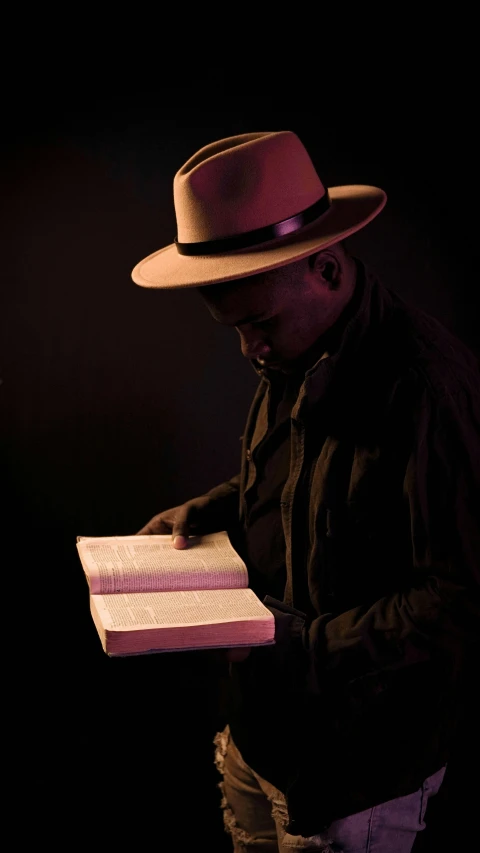 man in a hat holding a piece of cake in his hands