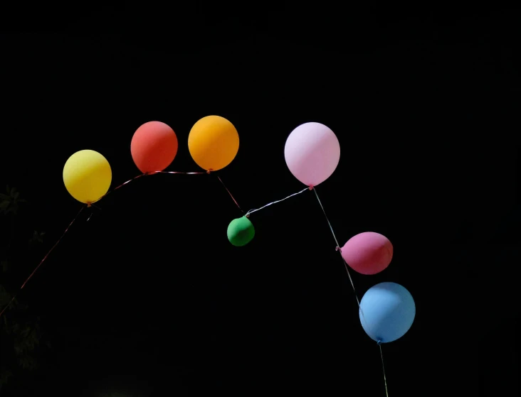 several balloons are in the air at night