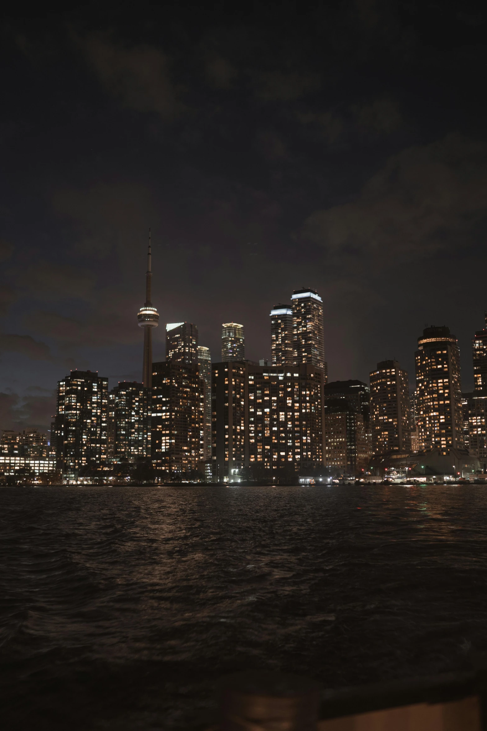 a view of a night city skyline from the ocean