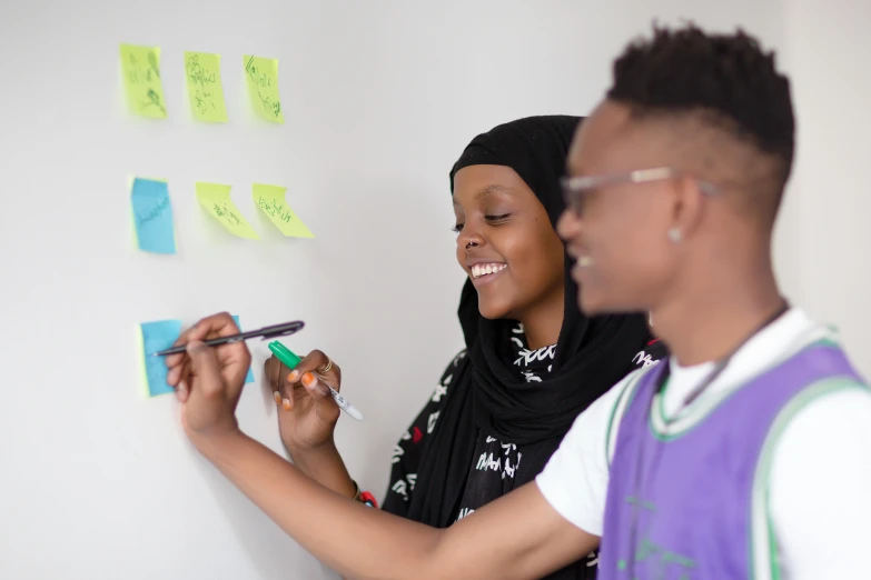 a woman and a boy in front of sticky notes