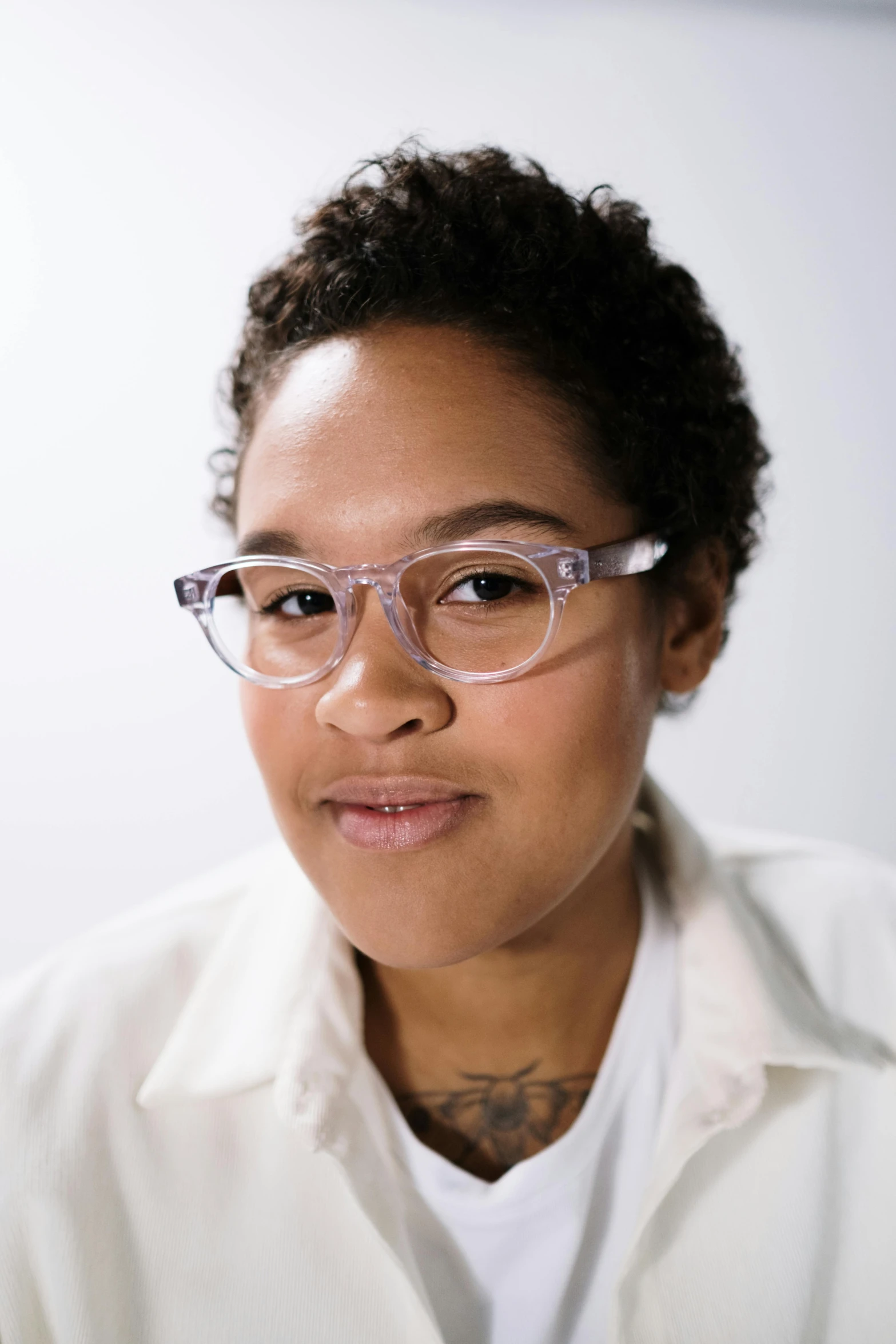 a woman with tattoos wearing glasses posing for a picture