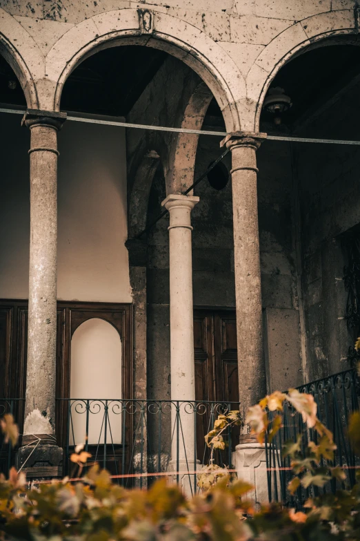 an old building with pillars and flowers