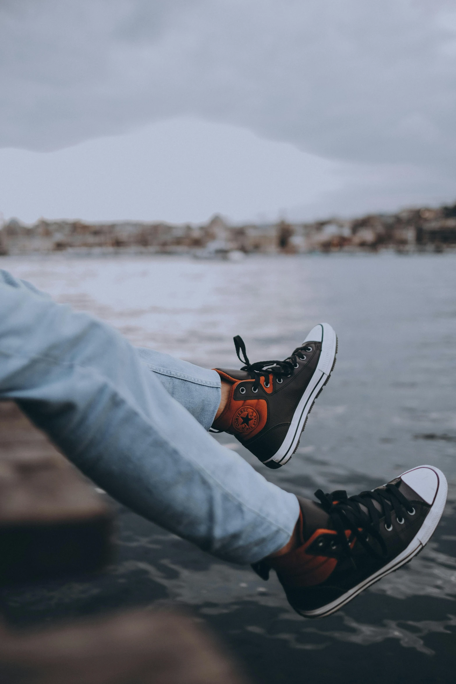 a person's feet on a dock next to water