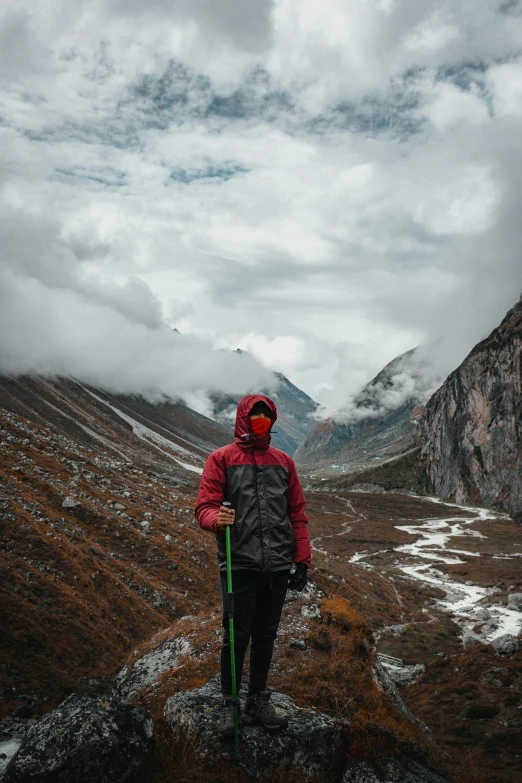 a person with a green ski pole standing on top of a mountain