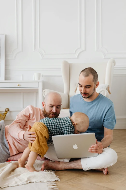 a man and woman are on the floor with an apple laptop