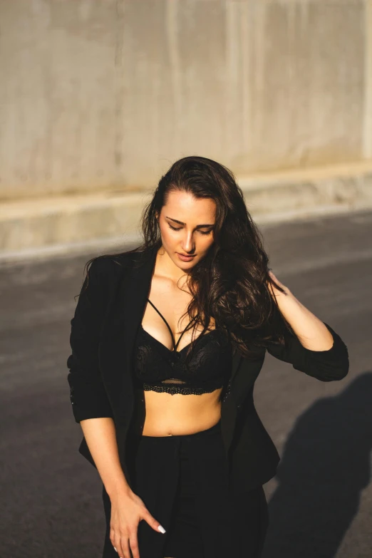 a woman with long dark hair wearing black clothing is leaning on her left hand