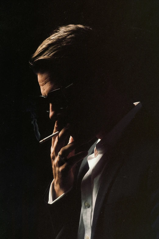 a man in suit and tie smoking cigarette