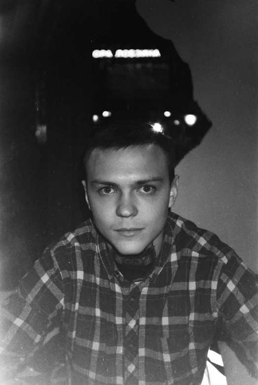 a young man with a hat sitting in front of a desk