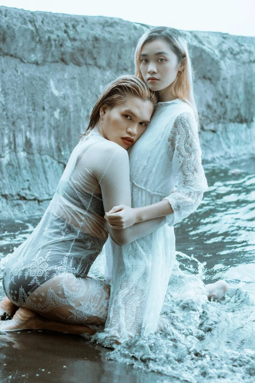 two women in a wet pose on the beach