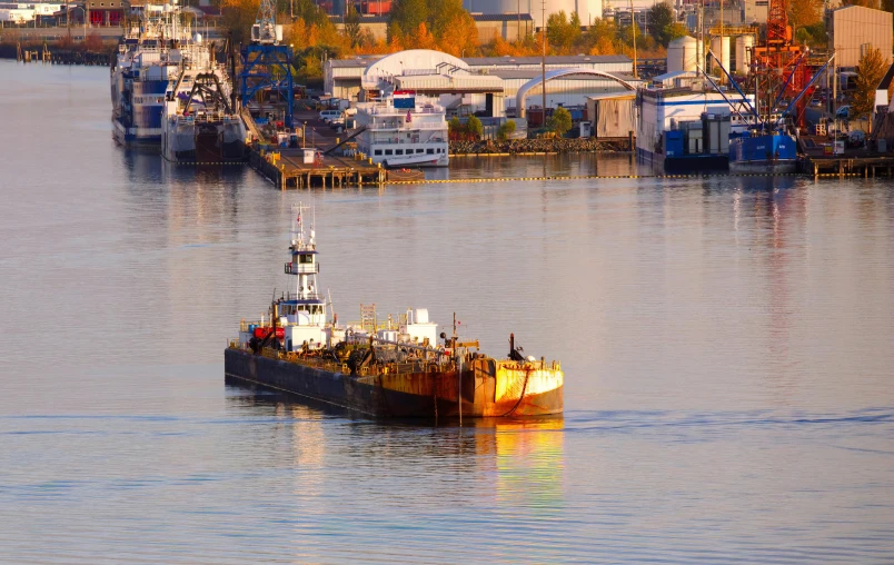 a small boat in the water beside a large pier