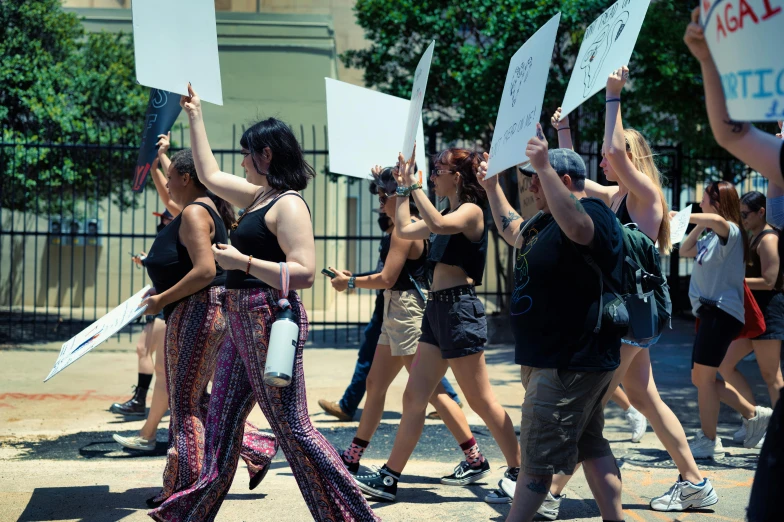 several women carry placards and walk in a demonstration