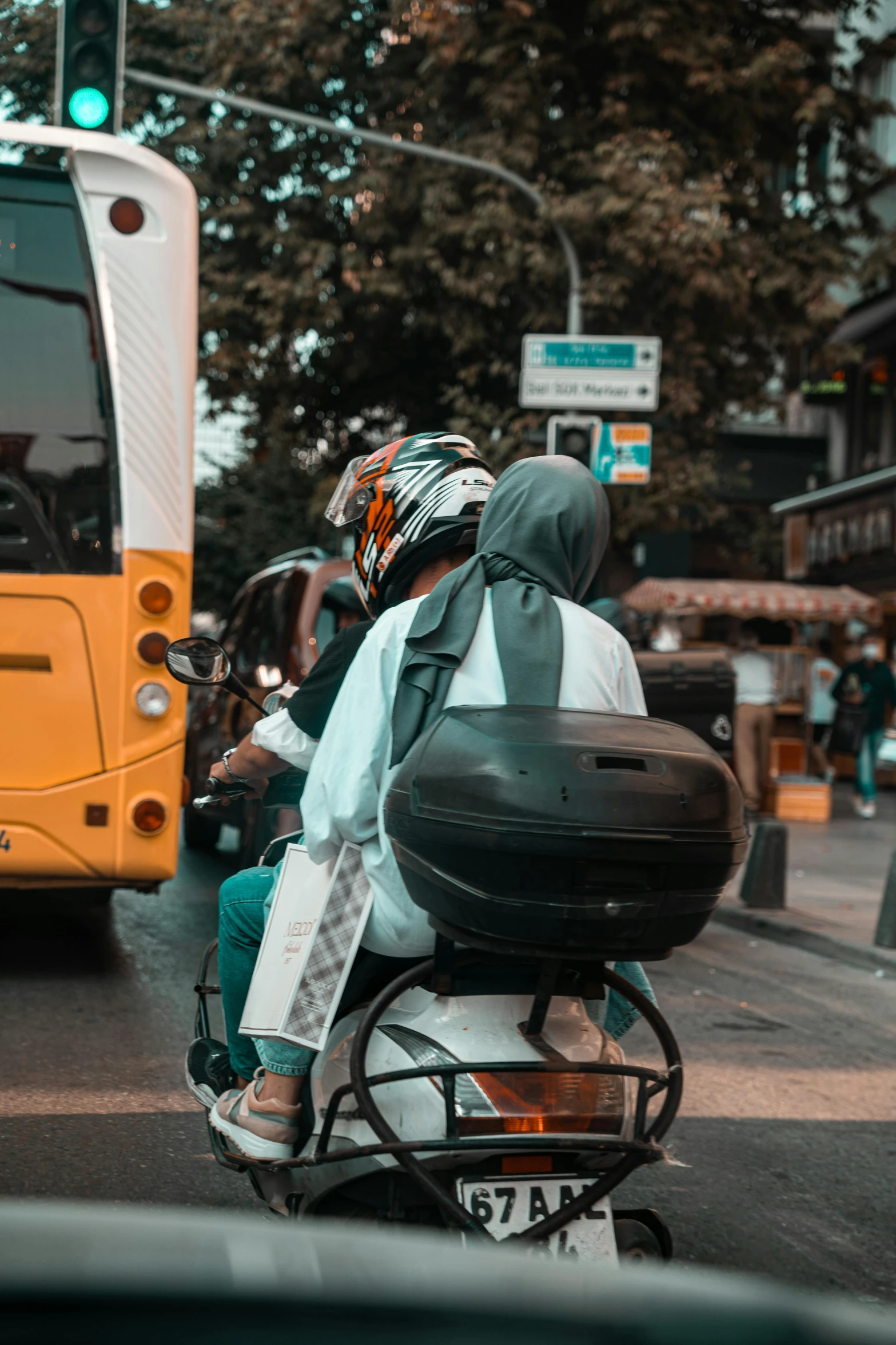 a person in a helmet on a motorcycle near a bus