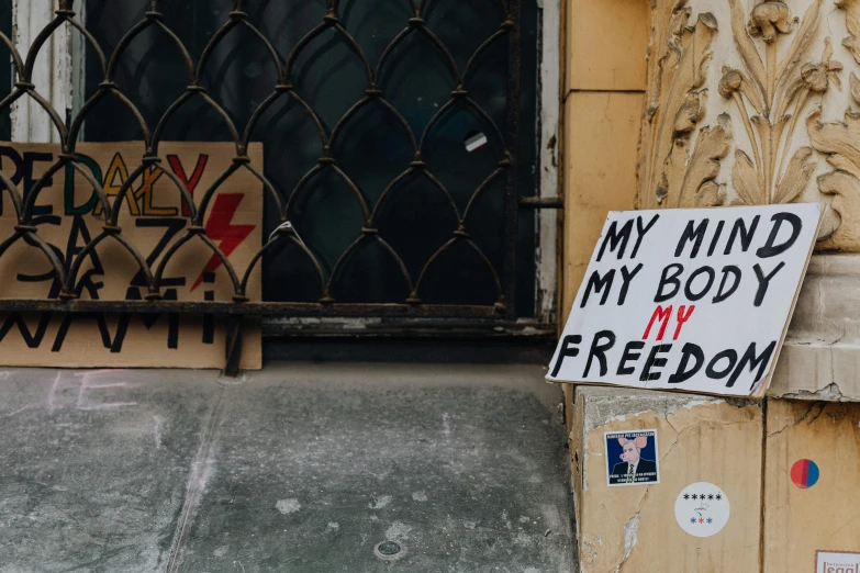 a sign posted on a wall that says, my mind my body my freedom