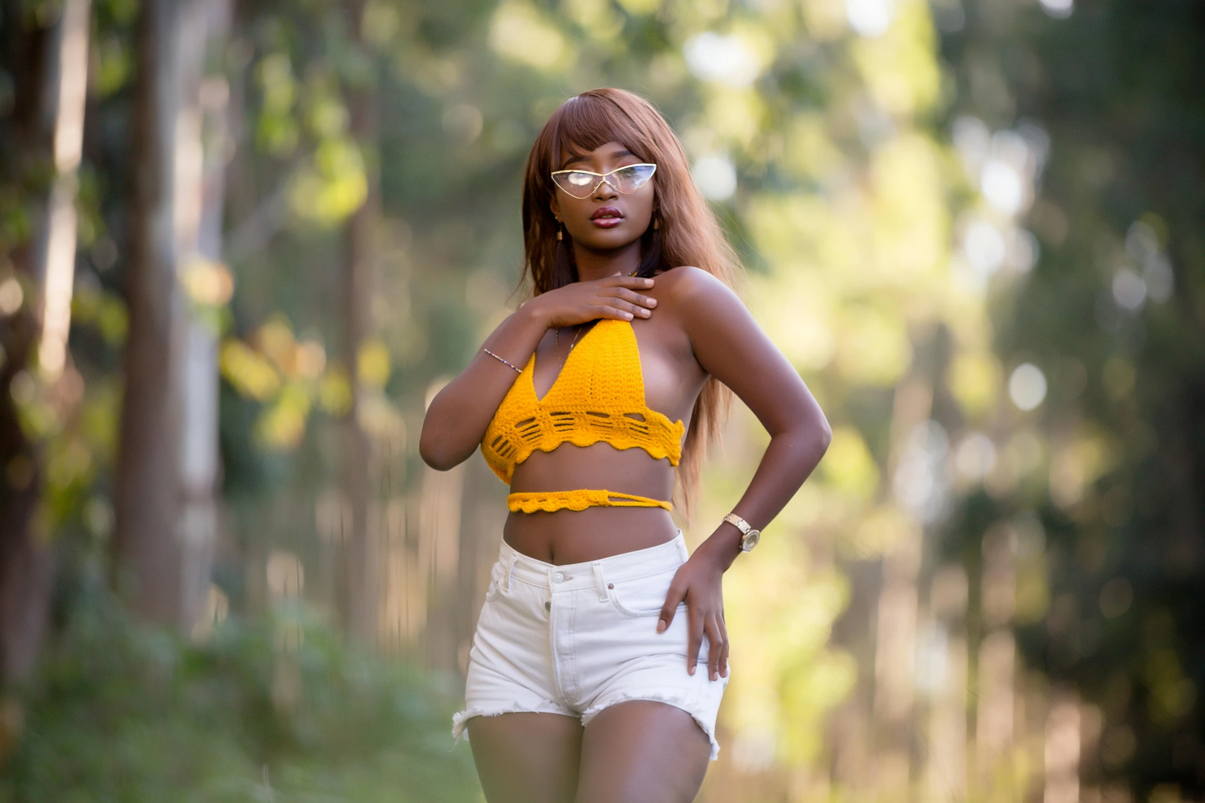 a woman in a yellow and white outfit walking down a path