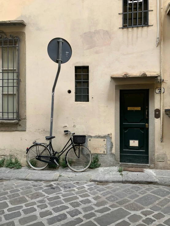 a bike is parked next to a building with a door and windows