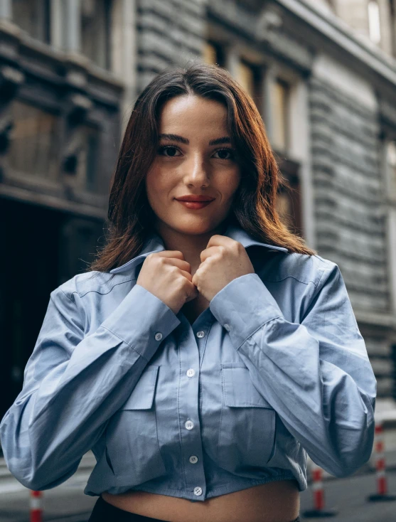 a woman is posing wearing a shirt and a skirt