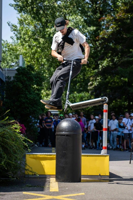 the man is on top of the pole with a scooter