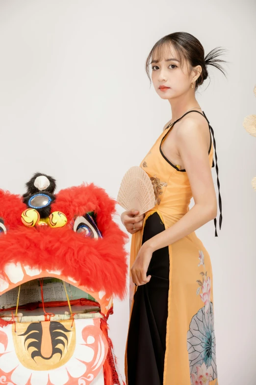 an oriental woman is posing with her costume next to a dragon