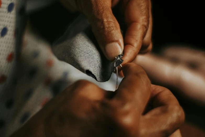 a man getting his necktie sewn together and tying it