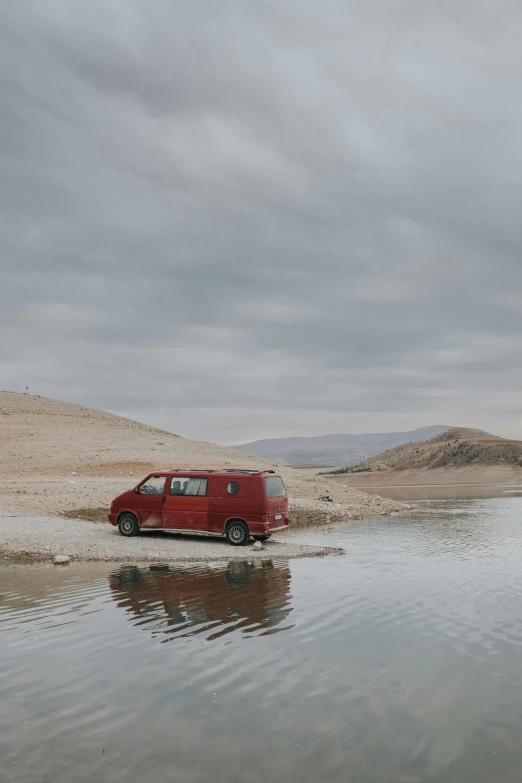 a van is parked near a body of water