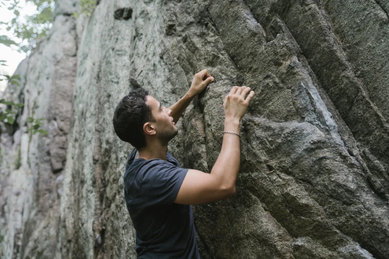 man with dark shirt climbing up and down rocks