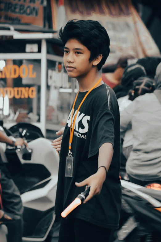 a young asian man standing next to a scooter