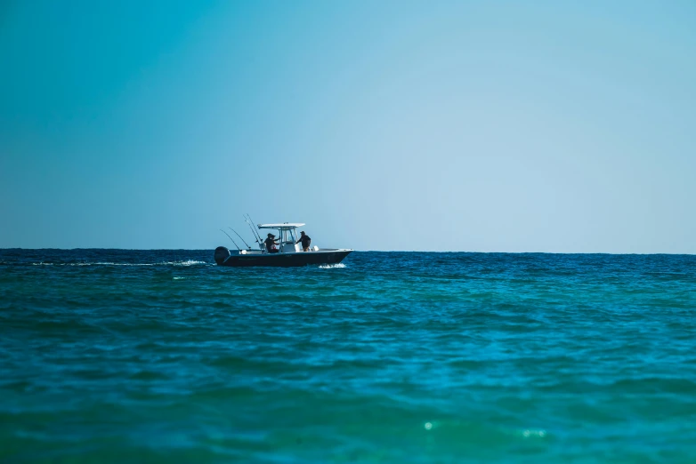 two people ride in a boat on a clear, sunny day