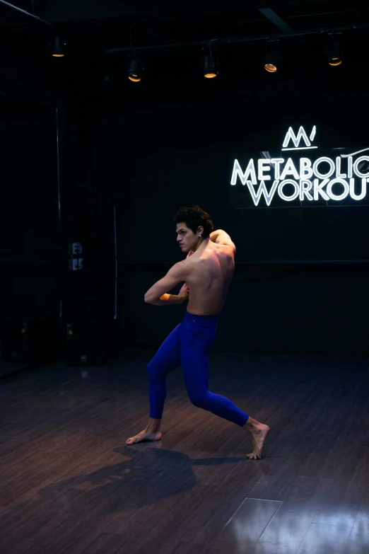 a man with  in blue pants running on a hardwood floor