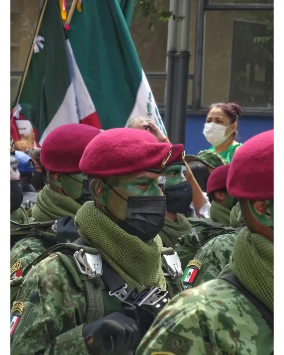 people wearing face masks are standing next to flags