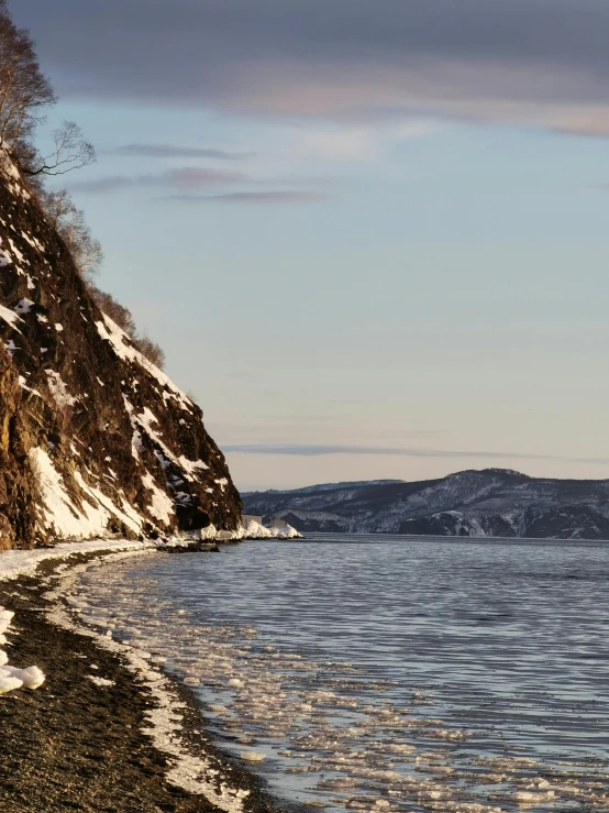 the bird is standing on the rocks overlooking the water