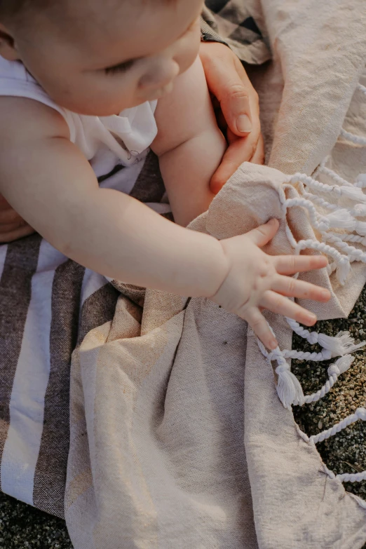 a close up of a child with one hand on a blanket