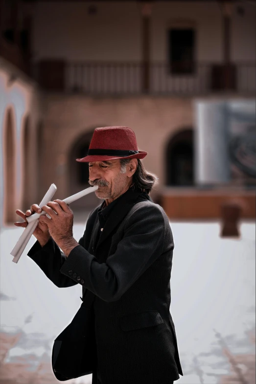 a man with a mustache in a red hat smoking a cigarette