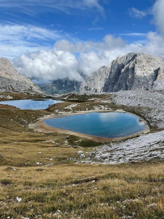 two large lakes on a small hill and mountains