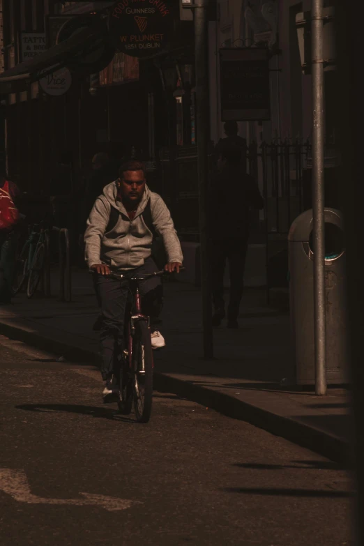 a man riding a bike down the middle of a street