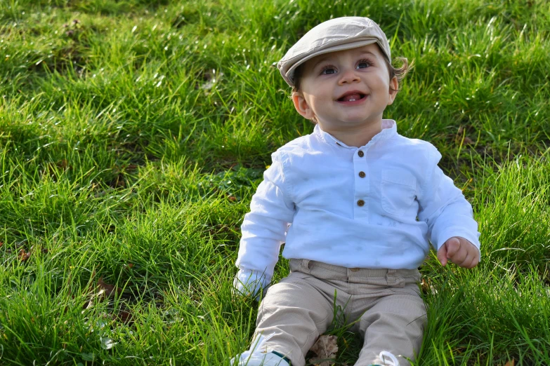 a baby is sitting on the grass