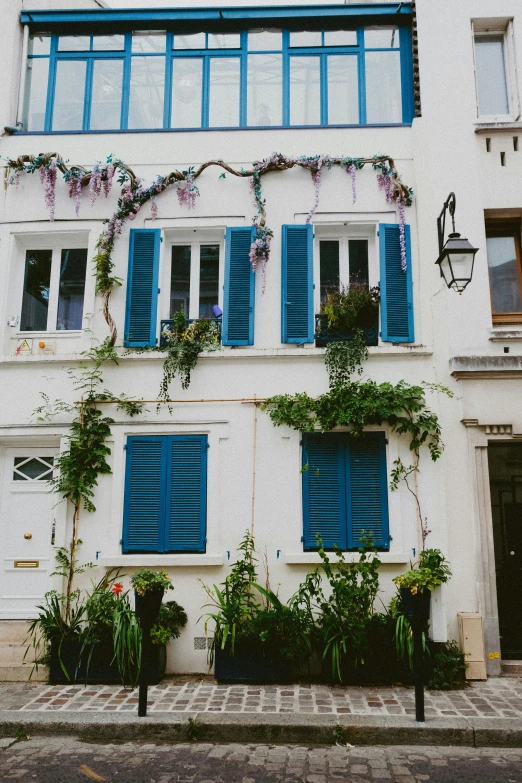 a very large white building with green plants growing out of it