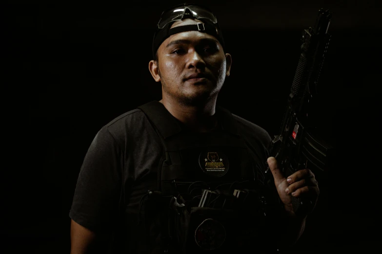 a man in black shirt holding up a machine gun