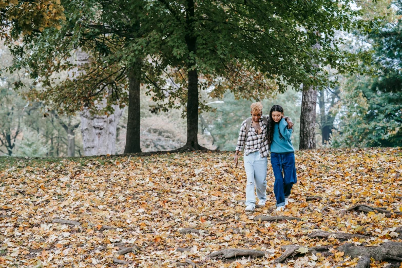 a couple of people walking through a forest