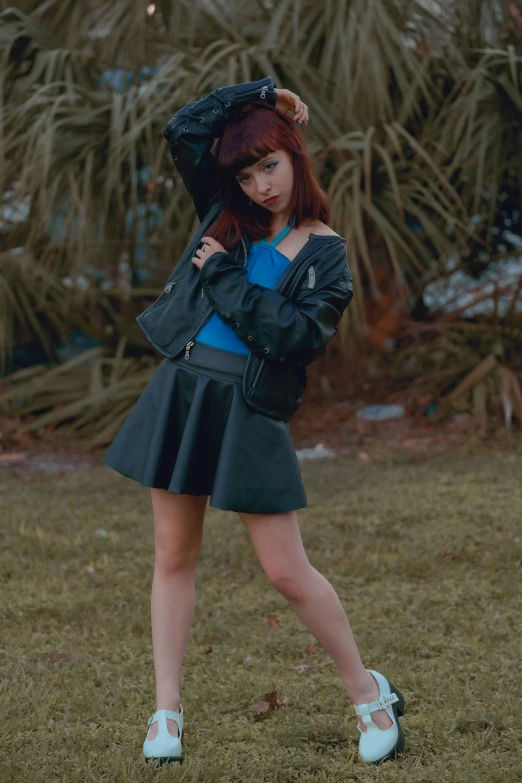 a young woman in a short skirt and jacket posing