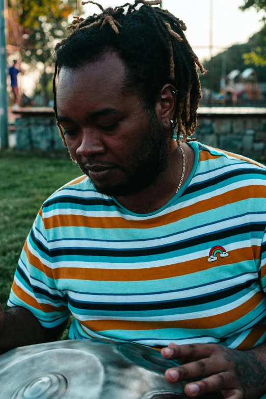 a person sits in a park holding a container