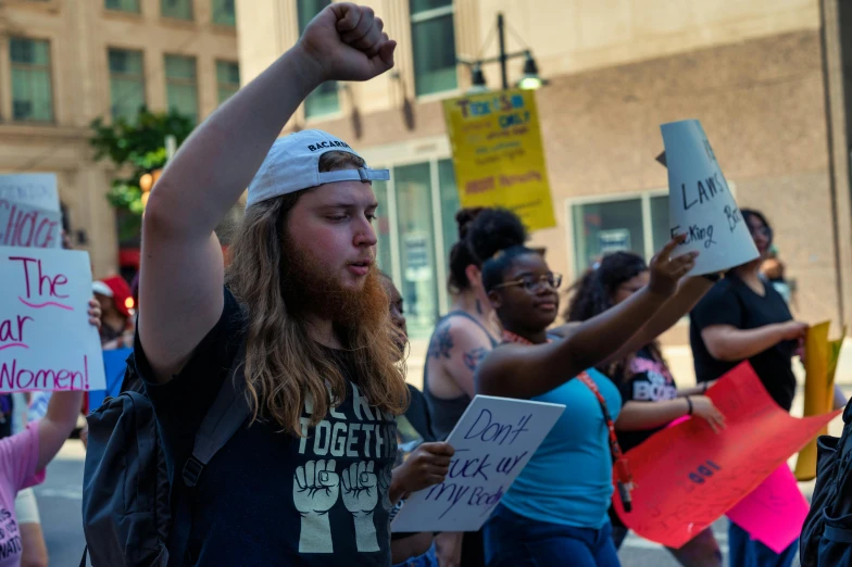 several protestors marching in a demonstration carrying signs