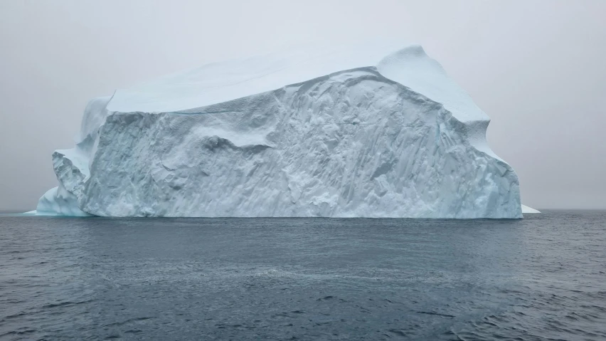 an iceberg floating in the middle of the ocean