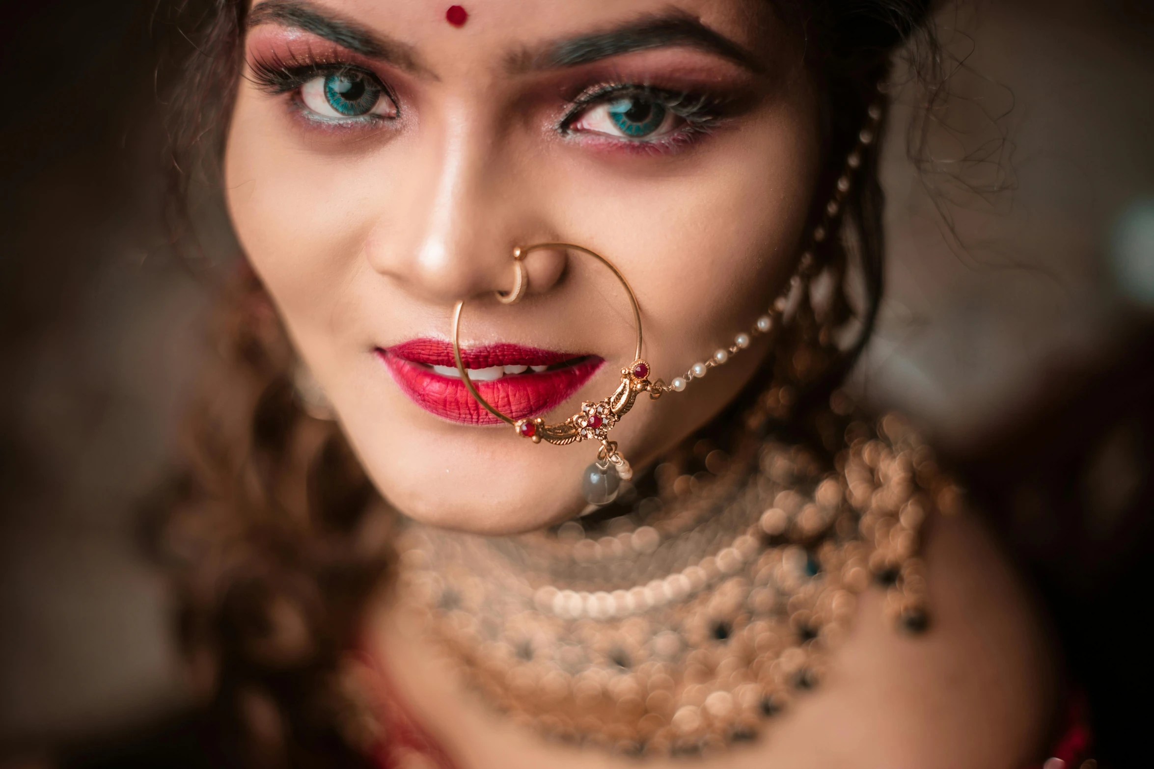 a girl with red and blue eyes and head jewelry